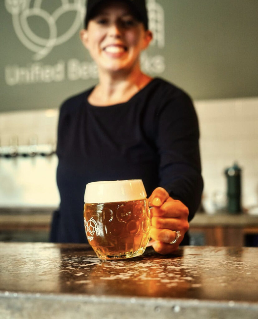 Beertender with mug of beer at bar